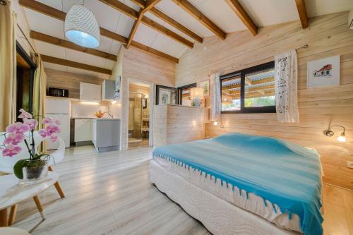 - une chambre avec un lit dans une pièce dotée de murs en bois dans l'établissement Ô Lagon ! Pieds dans l'eau au lagon de l'Ermitage, à Filaos