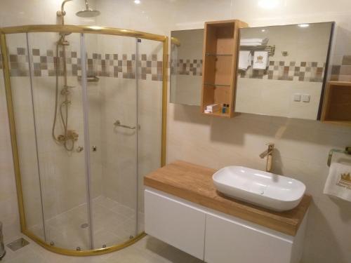W łazience znajduje się prysznic i biała umywalka. w obiekcie Golden Airport Hotel w mieście Dżibuti