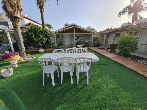 a white table and chairs on a lawn at בקתות היובל in Qiryat Shemona