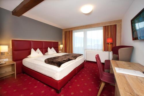 a hotel room with a large bed and a table at Hotel Bruno in Fügen