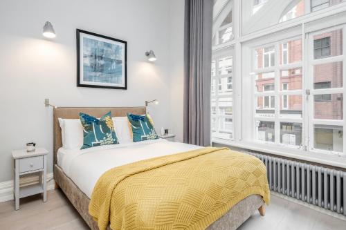 a bedroom with a bed and two windows at Kula London - Covent Garden St Martin's Lane in London