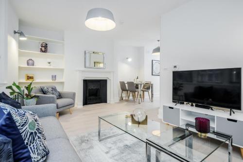 a living room with a couch and a tv at Stay Kula London - Covent Garden St Martin's Lane in London