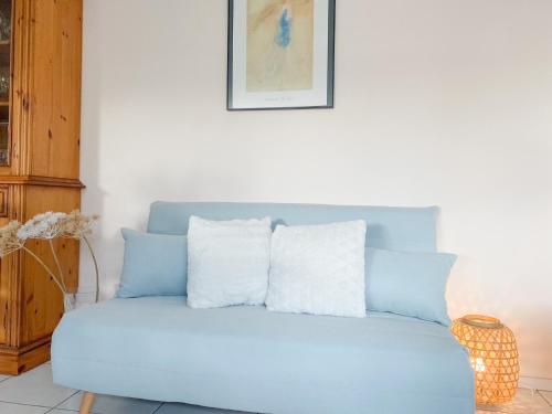eine blaue Couch mit vier Kissen darüber in der Unterkunft Vakantieappartement Park Loverendale 3 Domburg DO23 in Domburg