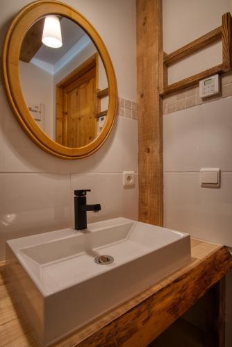 une salle de bain avec un lavabo blanc et un miroir dans l'établissement LES MURZIERS **, à Notre-Dame-de-Bellecombe