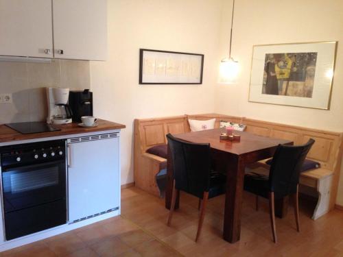 a kitchen with a table with chairs and a kitchen with a stove at Haus an der Therme in Bad Endorf