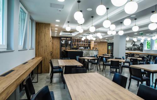 un restaurant avec des tables et des chaises en bois ainsi qu'un bar dans l'établissement Hotel Stal, à Stalowa Wola