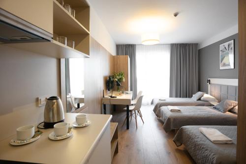 een hotelkamer met 2 bedden en een tafel met kopjes bij Apartments "Wolska Residence" in Warschau