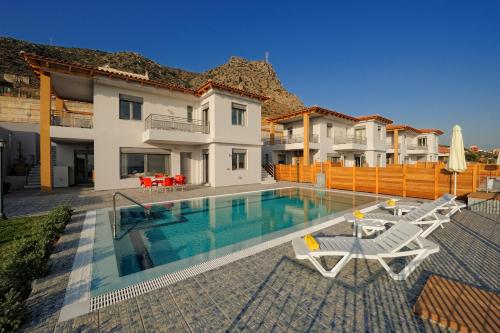 a villa with a swimming pool and two lawn chairs at Danae Villas in Hersonissos