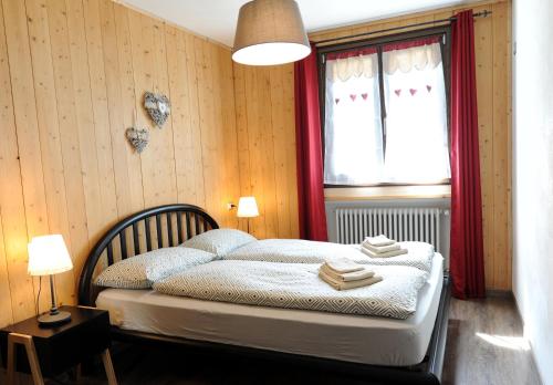 リヴィーニョにあるLa Suiteのベッドルーム1室(赤いカーテンと窓付きのベッド1台付)