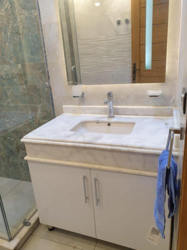 a bathroom with a white sink and a mirror at New Apartment AlMohandessin near Shehab street in Cairo