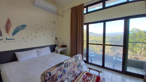 a bedroom with a bed and a large window at 三義竺夢園 漫步山林 漫遊桐花 in Sanyi