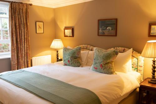 a bedroom with a bed with white sheets and pillows at Spread Eagle Hotel And Spa in Midhurst