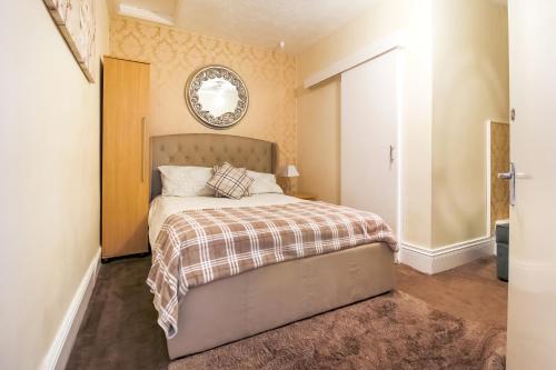 a bedroom with a bed and a mirror on the wall at Hotel Mj Kingsway, Cleethorpes Seafront in Cleethorpes