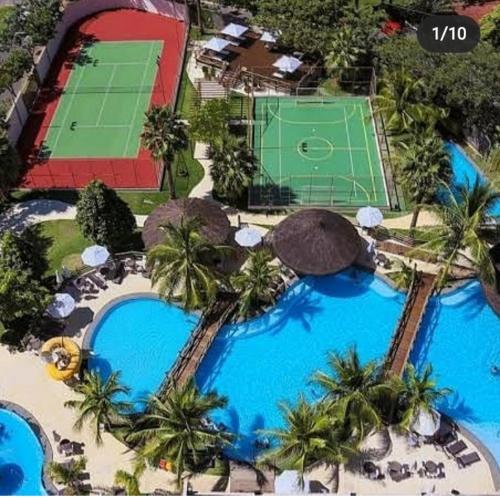- une vue aérienne sur un complexe avec 2 piscines et un court de tennis dans l'établissement SUITES LE JARDIN CALDAS NOVAS, à Caldas Novas