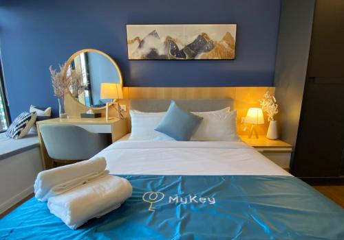 a bedroom with a large bed with a blue wall at Ceylonz Starlight Suites Bukit Bintang in Kuala Lumpur