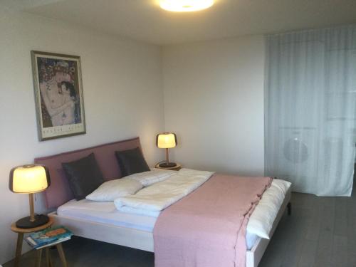 1 dormitorio con 1 cama grande y 2 lámparas en findling-ferien Bern West, en Säriswil