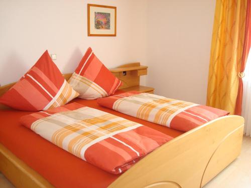 a bedroom with two beds with orange and orange pillows at Ferienwohnung Glückstein in Großeibstadt