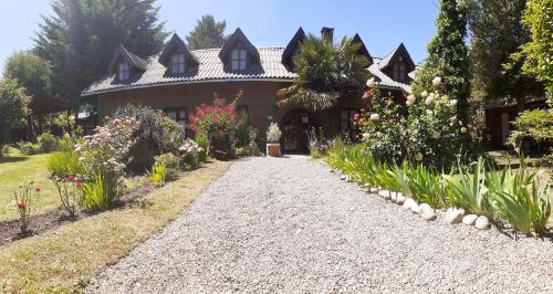 una casa con un jardín delante de ella en Rayentray en El Bolsón