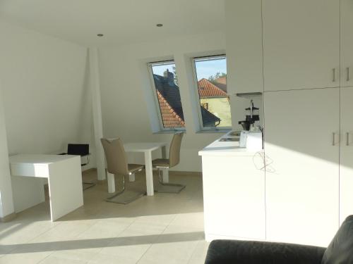 a white room with a table and a table and chairs at südausgerichtetes Apartment SüdWest Kleinmachnow in Kleinmachnow