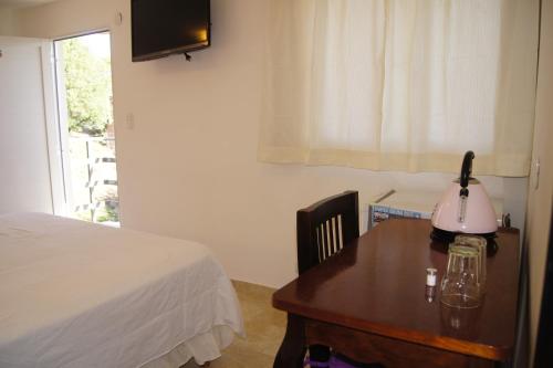 1 dormitorio con 1 cama y 1 mesa con lámpara en La Herradura, en Mina Clavero