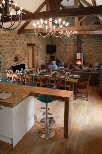 a dining room with a table and a couch at Woodpecker Loft at Millfields Farm Cottages in Ashbourne
