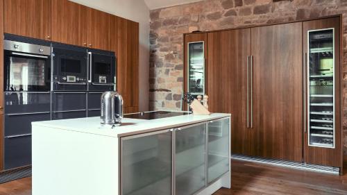 a kitchen with a white counter and wooden cabinets at Woodpecker Loft at Millfields Farm Cottages in Ashbourne