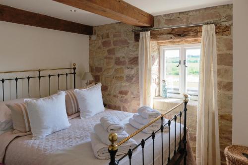 a bedroom with a bed with towels on it at Woodpecker Loft at Millfields Farm Cottages in Ashbourne