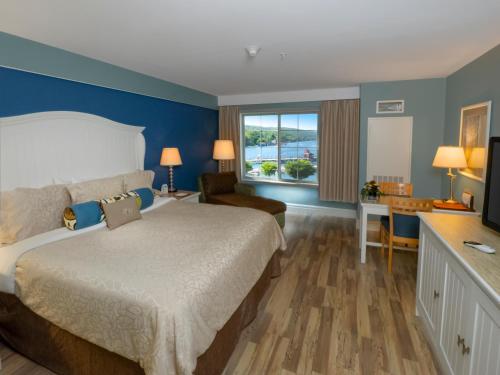 ワトキンズ・グレンにあるWatkins Glen Harbor Hotelのベッドとデスクが備わるホテルルームです。