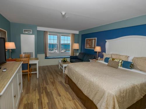 a hotel room with a bed and a couch at Watkins Glen Harbor Hotel in Watkins Glen