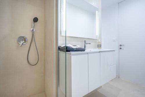 uma casa de banho branca com um lavatório e um chuveiro em Giovannina N3 em Cassis
