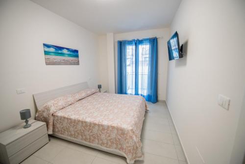 a white bedroom with a bed and a window at Home Square in Milazzo