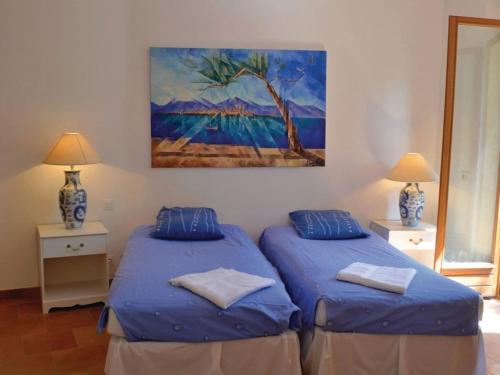 two beds in a room with a painting on the wall at Peaceful spacious 3 bed Villa in Callian