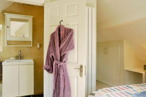 a towel hanging on the door of a bedroom at Immaculate Quiet Coach House in Garden Birmingham in Birmingham