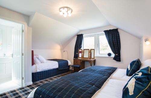 a bedroom with two beds and a window at Juniper Hill near Loch Achilty on the NC500 in Contin