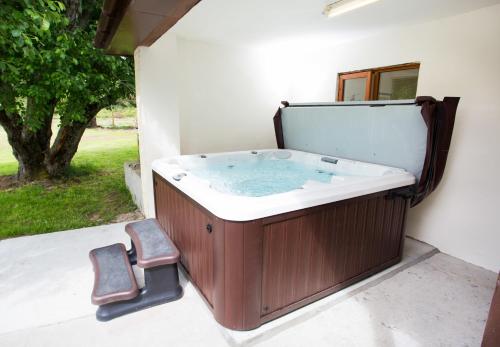 a hot tub with two chairs sitting next to it at Juniper Hill near Loch Achilty on the NC500 in Contin