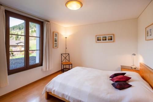 a bedroom with a bed and a large window at Luxury Alpine Apartment in Chateau-d'Oex