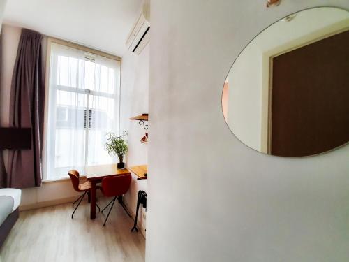 a room with a mirror on a wall and a desk at Boutique Hotel Joure - centrum & haven in Joure