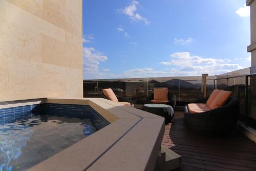 a patio with a hot tub and chairs on a balcony at Suncheon Hotel Gite in Suncheon