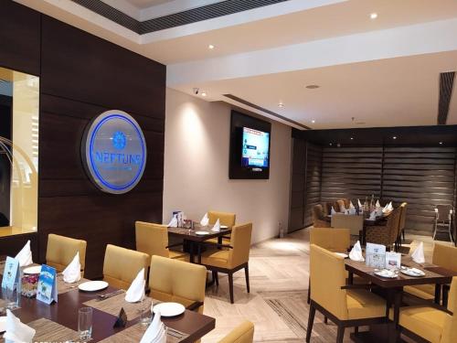 a dining room with tables and chairs and a television at Fortune District Centre, Ghaziabad - Member ITC Hotels' Group in Ghaziabad