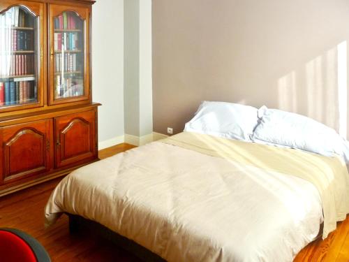 a bedroom with a bed and a wooden cabinet at Maison accueillante à Lanester - Confort et espace pour 6 pers. in Lanester