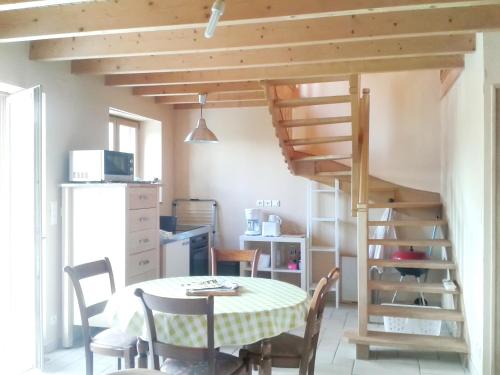 Cette chambre comprend une table et une mezzanine. dans l'établissement Maison accueillante à Plehedel avec jardin et parking privé, à Pléhédel