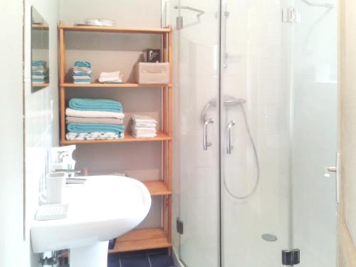 a bathroom with a white sink and a shower at Maison accueillante à Plehedel avec jardin et parking privé in Pléhédel
