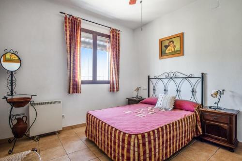 1 dormitorio con cama con sábanas rosas y ventana en 5 bedrooms house with private pool and enclosed garden at Carcabuey, en Carcabuey