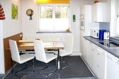 eine Küche mit einem Holztisch und weißen Stühlen in der Unterkunft 3 bedrooms house with enclosed garden and wifi at Purgstall in Hart