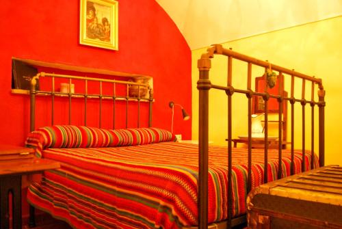 sypialnia z łóżkiem z czerwoną ścianą w obiekcie Comfortable house in Guadix with barbecue and parking w mieście Guadix
