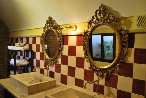 łazienka z umywalką i 2 lustrami na ścianie w obiekcie Comfortable house in Guadix with barbecue and parking w mieście Guadix