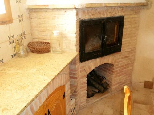 a brick fireplace in a kitchen with a counter top at Comfortable Chalet in Masdenverge with Private Pool in Masdenverge