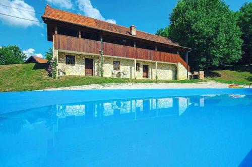 una casa con una piscina de agua frente a ella en 4 bedrooms villa with city view private pool and jacuzzi at Mozdenec en Možđenec
