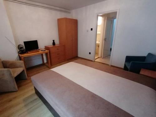 sala de estar con cama y escritorio con ordenador en Szilvió en Gyenesdiás