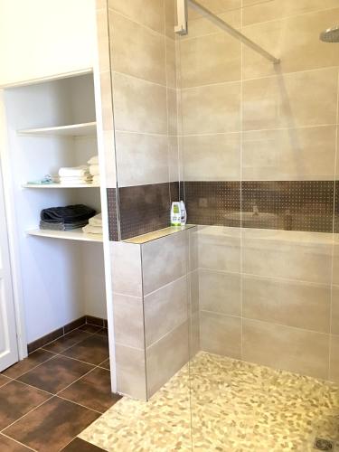 une douche avec une porte vitrée dans une salle de bain dans l'établissement Maison charmante à Montauriol avec jardin et piscine privée., à Montauriol